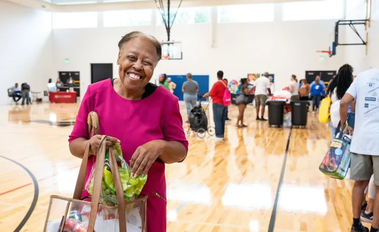 Lady smiling with a bag of goodies at the Health Expo
